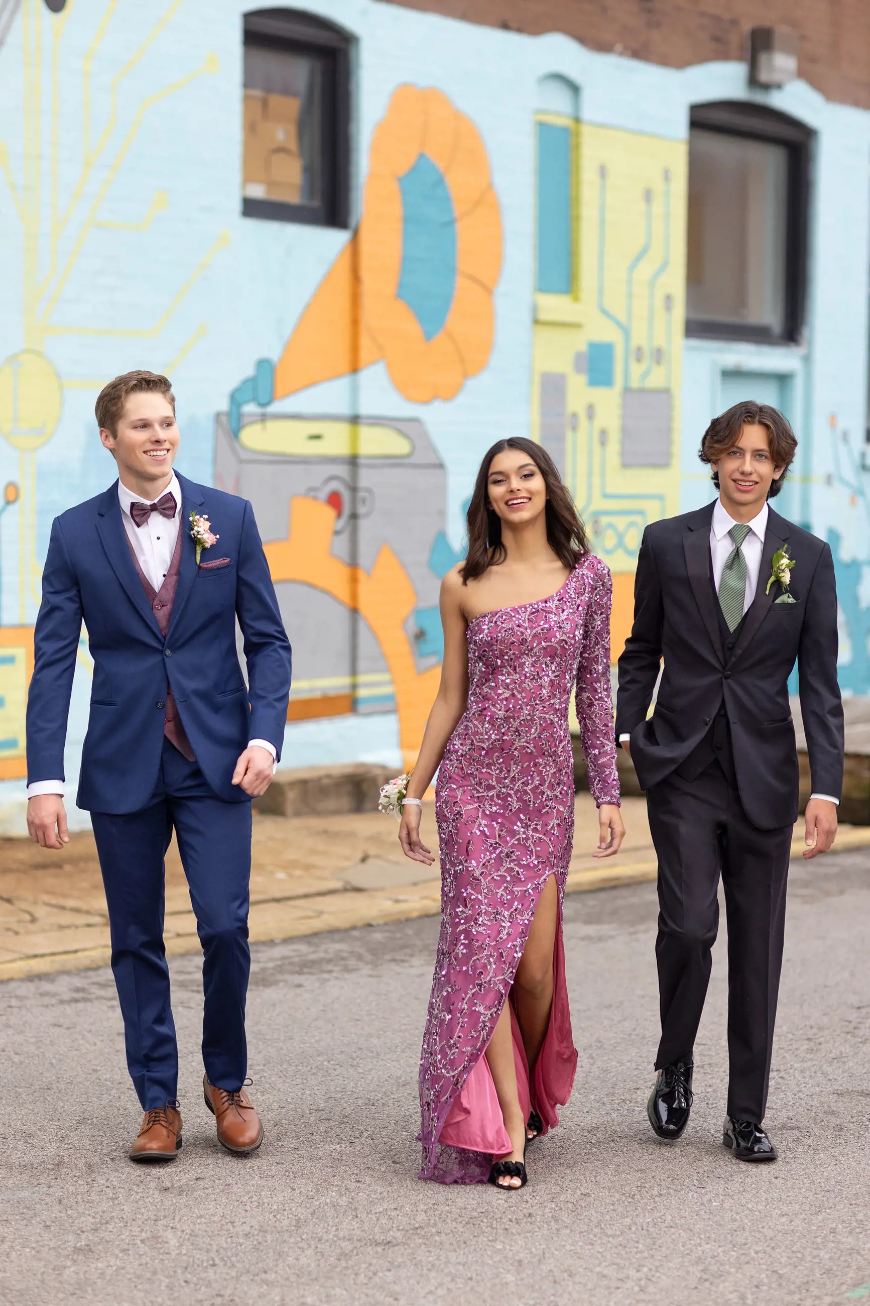 Models wearing a pink gown, black and blue suits