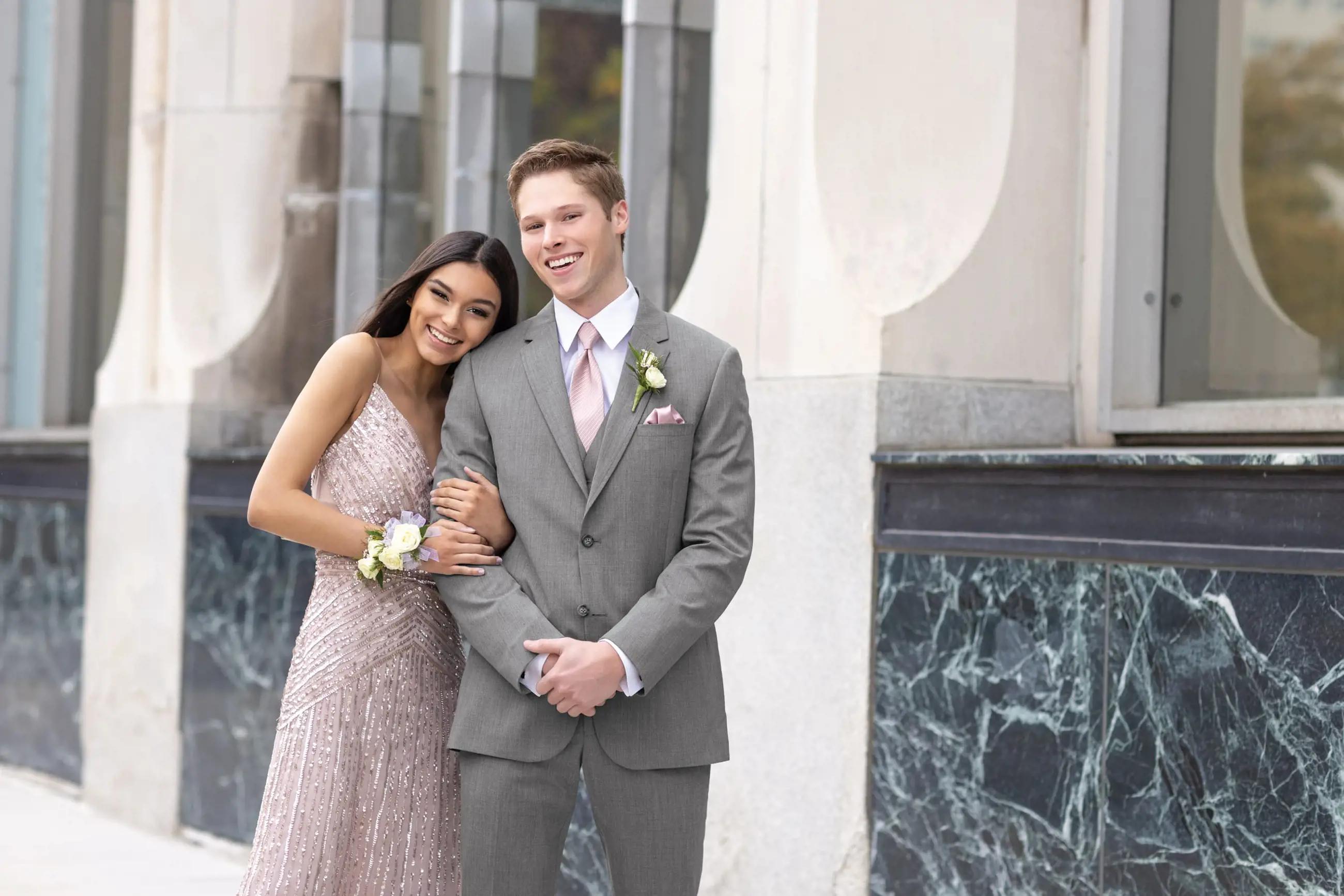 Сouple wearing a light-pink gown and a gray suit