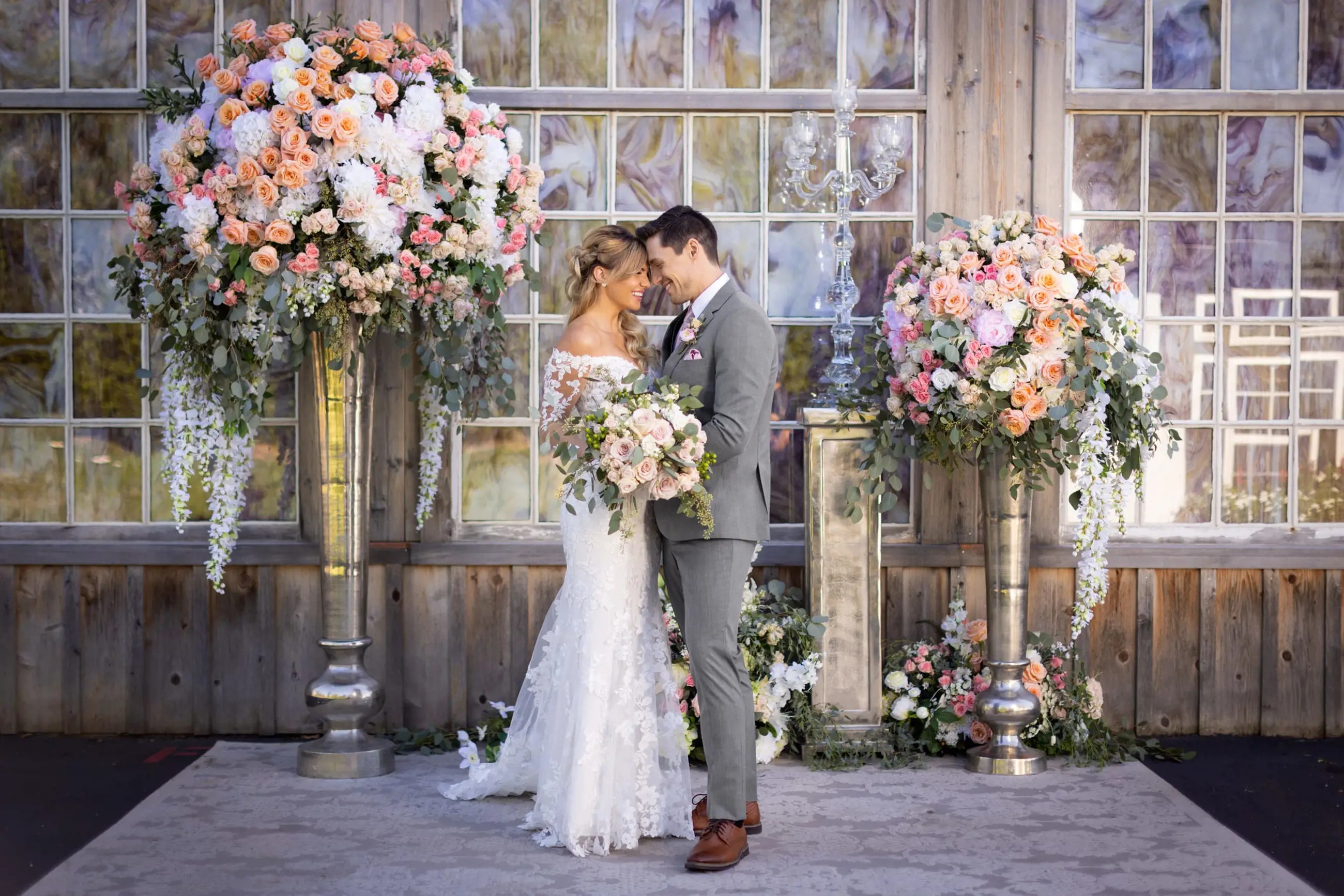 Сouple wearing a light-pink gown and a gray suit with a flowers